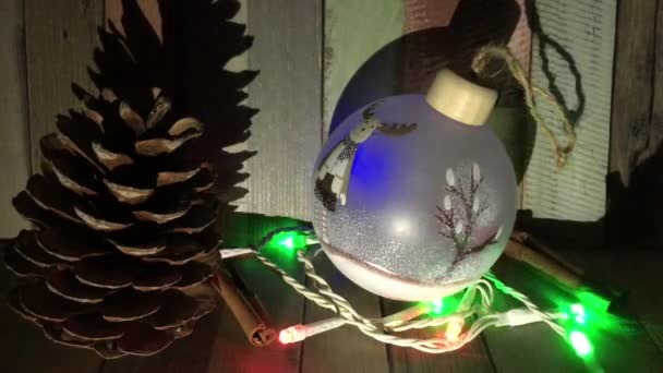 Полупрозрачный Мяч Рождественская Висячая Игрушка Лежит Рядом Мигающей Гирляндой Свет — стоковое видео
