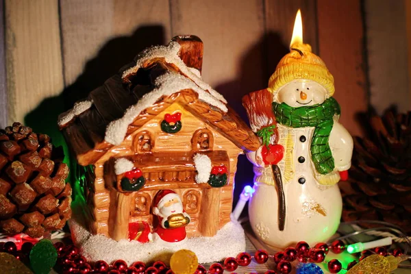 Speelgoedhuis Santa Claus Gepoederd Met Sneeuw Naast Een Sneeuwpop Kaars — Stockfoto