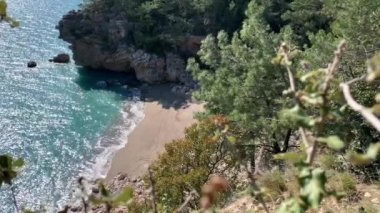Dağların, kayaların, kumların, deniz dalgalarının arasında harika bir kumsalın yüksekliğinden manzara sürekli sahile gelen rüzgar ağaçları sallıyor, çoğunlukla çam ağaçları, doğayı izlerken bir an rahatlama, denizin sesi, karantinadaki anılar.