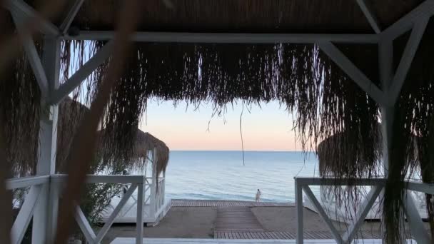 Blick Vom Strandzelt Mit Strohdach Auf Das Meer Früher Abend — Stockvideo