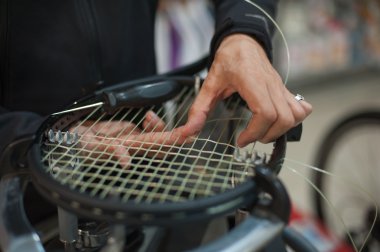 Tenis stringer elinde raket çekimi yaparken yakın çekim