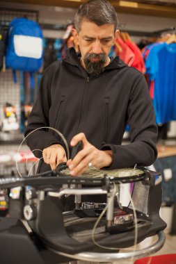 Tığ tutarak ve raket çekimi yapıyor Tenis stringer