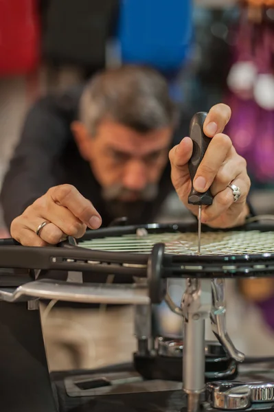 Stringer de tênis segurando awl e fazendo cordas raquete — Fotografia de Stock