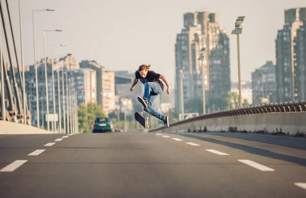 Skater robi triki i skoki na ulicy mostem — Zdjęcie stockowe