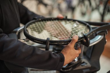 Tenis stringer elinde raket çekimi yaparken yakın çekim