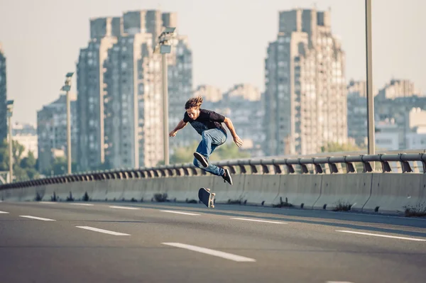 Skater haciendo trucos y saltando en el puente de la carretera de la calle —  Fotos de Stock