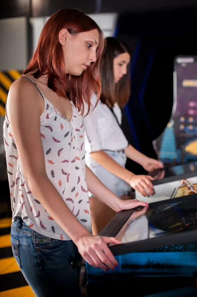 Jonge vrouw spelen op de flipperkast — Stockfoto