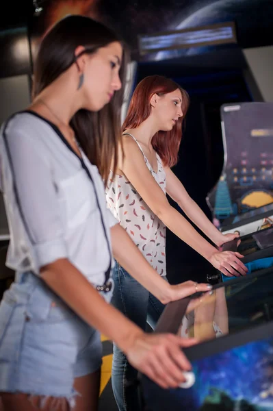 Jonge vrouw spelen op de flipperkast — Stockfoto