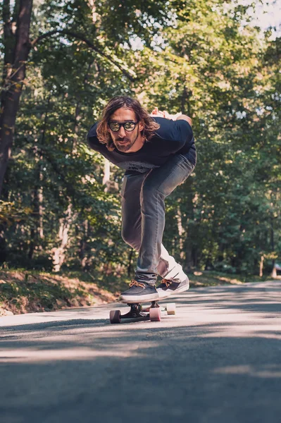 Longboard skating - Skateboarder cavalcare un longboard attraverso il fo — Foto Stock