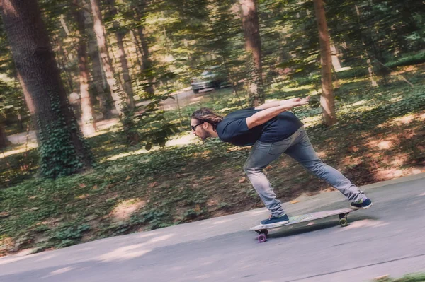 Patinaje Longboard - Skateboarder montar un longboard a través del fo —  Fotos de Stock