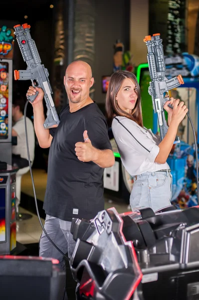 Jovem casal posando com uma espingarda de brinquedo — Fotografia de Stock