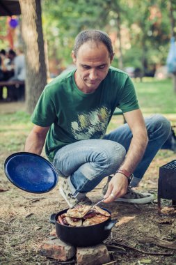Yapım barbekü ve koyar adam tencerede et kavrulmuş