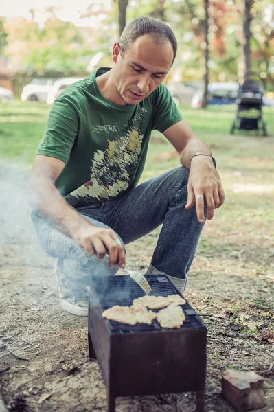 Homem fazendo churrasco no parque — Fotografia de Stock