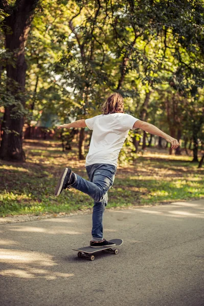 Skateboarder rijden op een helling door het bos — Stockfoto