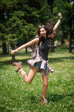 Eğleniyor ve güneşli bir günde ormanda atlama genç kadın