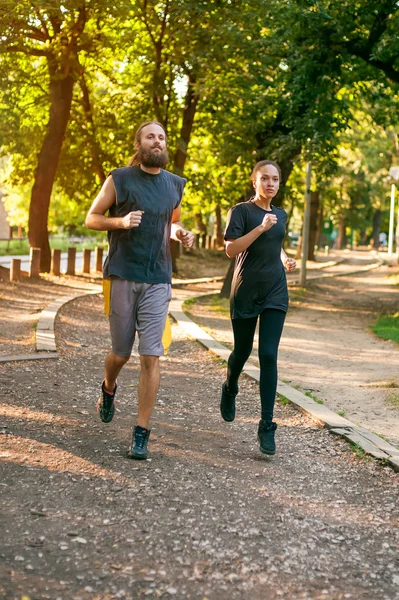 Junges Paar läuft auf der Joggingstrecke durch den Wald — Stockfoto
