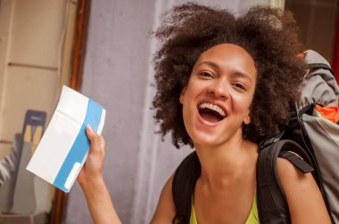 Mutlu ve keyifli backpacker kadın turist için bilet ortaya