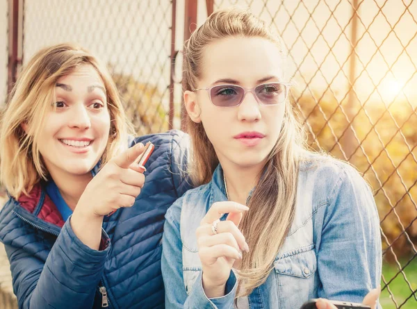 Zwei Freundinnen lachen und zeigen mit dem Finger — Stockfoto