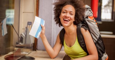 Mutlu ve keyifli backpacker kadın turist için bilet ortaya