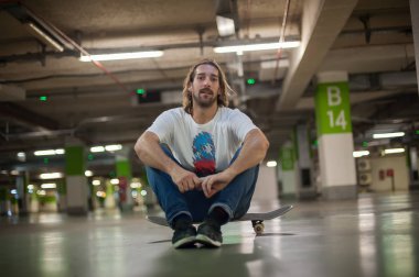 Yeraltı garajına onun kaykay üzerinde oturan kaykaycı