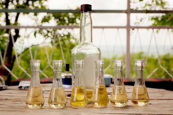 Bottle of plum brandy with small glasses on wooden table — Stock Photo, Image