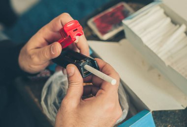 Sigara içen adam rulo haddeleme makine kullanarak tütün Sigara