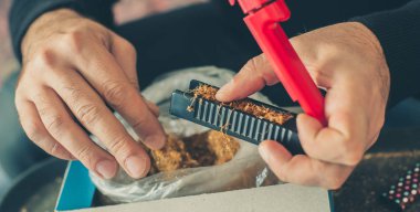 Sigara içen adam rulo haddeleme makine kullanarak tütün Sigara