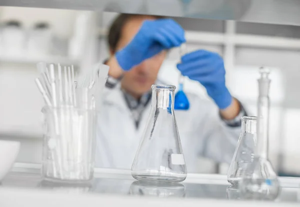 Male laboratory researcher performs tests with blue liquid — Stock Photo, Image