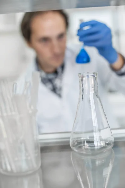 Investigador de laboratorio masculino realiza pruebas con líquido azul —  Fotos de Stock