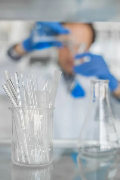 Αρσενικό εργαστήριο ερευνητής εκτελεί δοκιμές με μπλε υγρό — Φωτογραφία Αρχείου