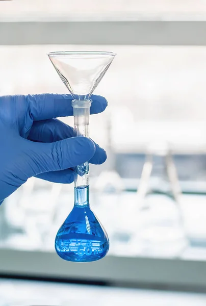 Technicien de laboratoire effectue des tests et verser du liquide bleu — Photo