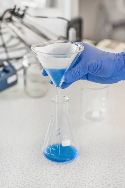 Laboratory technician performs tests and pouring blue liquid — Stock Photo, Image