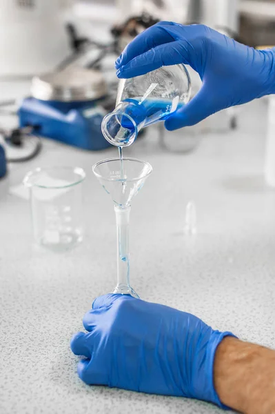 Laboratory technician performs tests and pouring blue liquid — Stock Photo, Image