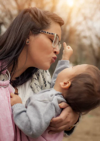 Ung mamma med hennes pojke i en baby carrier halsduk — Stockfoto