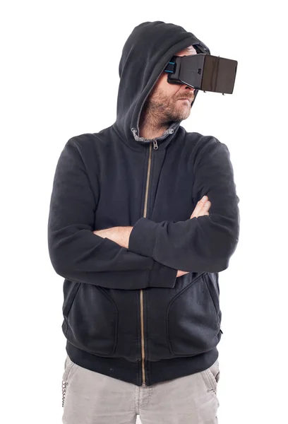 Hombre con capucha y brazos cruzados utilizar un dispositivo de realidad virtual —  Fotos de Stock