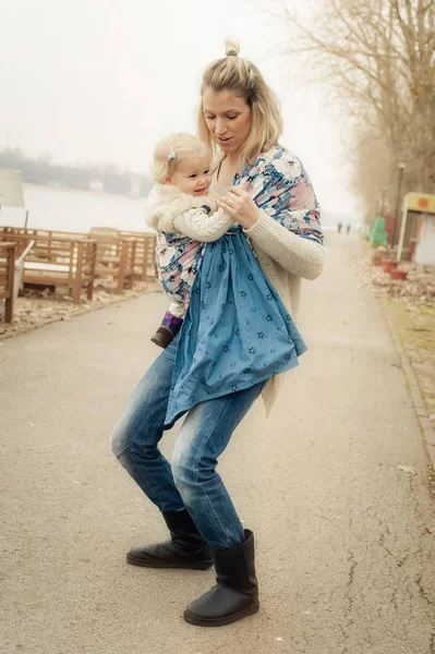 Genç anne bebek taşıyıcı eşarp küçük kızı olan — Stok fotoğraf