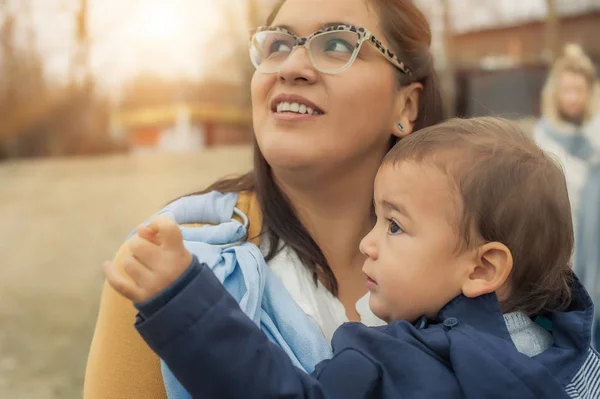 Ung mamma med hennes pojke i en baby carrier halsduk — Stockfoto