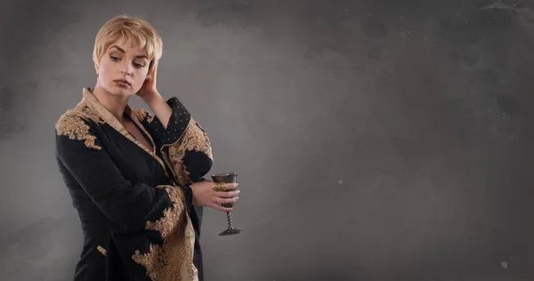 Mulher de moda renascentista segurando cálice com vinho — Fotografia de Stock