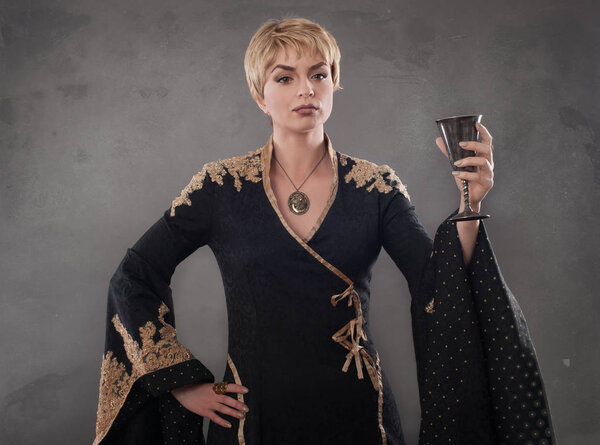 Renaissance fashion woman holding goblet with wine