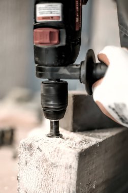 Onun iş marangozluk atölye için elektrikli matkap kullanarak marangoz