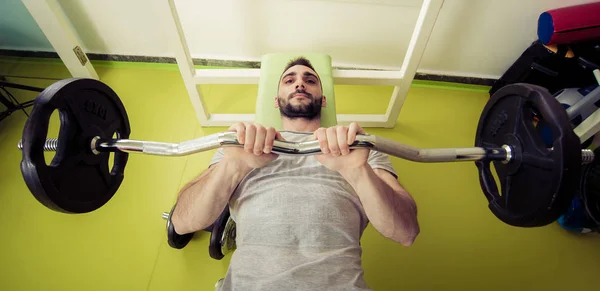 Sportivo uomo sollevare pesi in palestra — Foto Stock