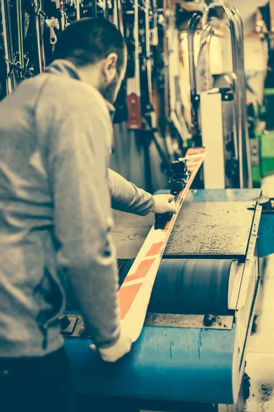 Afinación y recapitulación de esquí. Trabajador de tienda de invierno haciendo reparación base — Foto de Stock