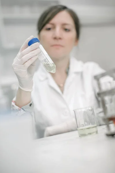 Επιστήμονες του ιατρικού εργαστηρίου κρατώντας έναν σωλήνα δοκιμής με το δείγμα — Φωτογραφία Αρχείου