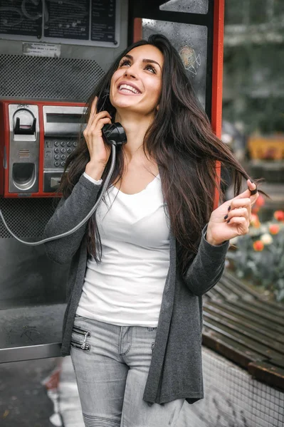 快乐和微笑的女孩子说话在复古的电话亭 — 图库照片