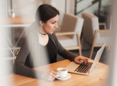 Bir kahve içme ve internette sörf gülümseyen genç kadın