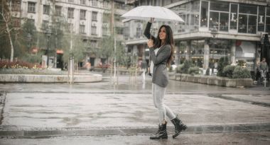 Mutlu gülümseyen kadın yağmur şemsiyesi altında