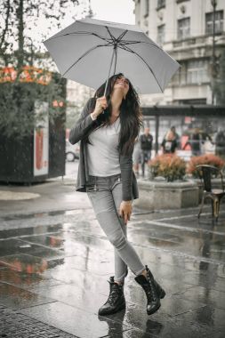 Mutlu gülümseyen kadın yağmur şemsiyesi altında