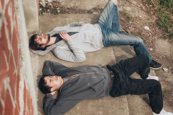 Два друга лежат на земле и курят траву. — стоковое фото