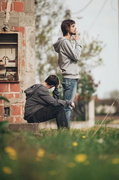 Two friends smoking joint in abandoned ghetto part of city — Stock Photo, Image
