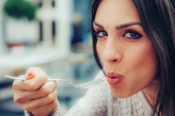 Young woman enjoying food in a restaurant, having her lunch brea